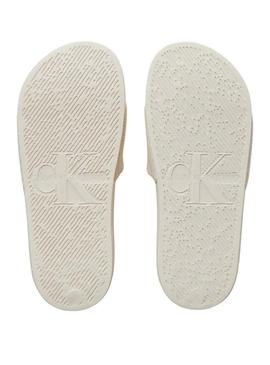 Chinelos Calvin Klein de monograma bege para mulher.